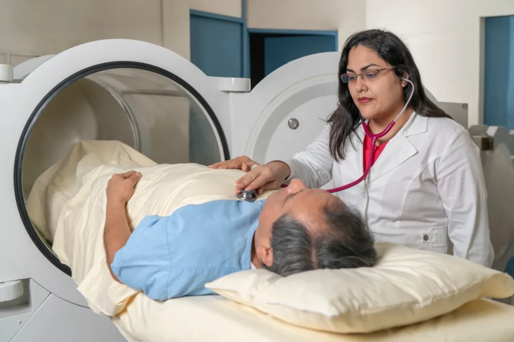 Doctor with patient laying on a bed near a medical chamber device