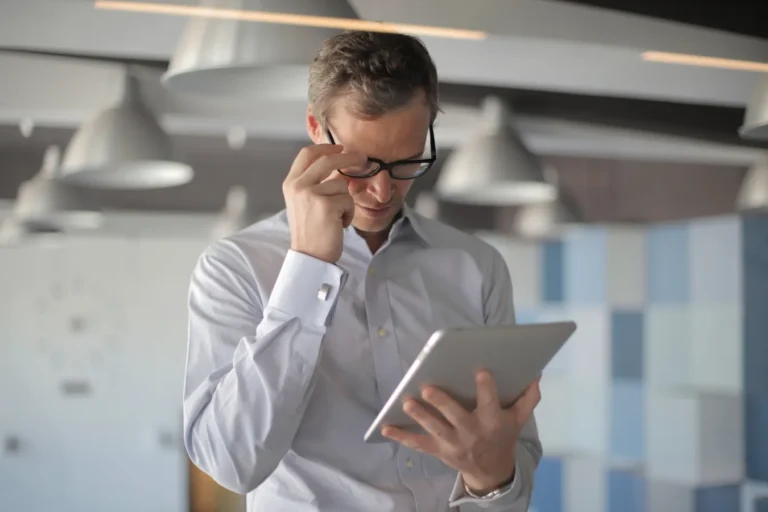 Man with glasses looking at tablet