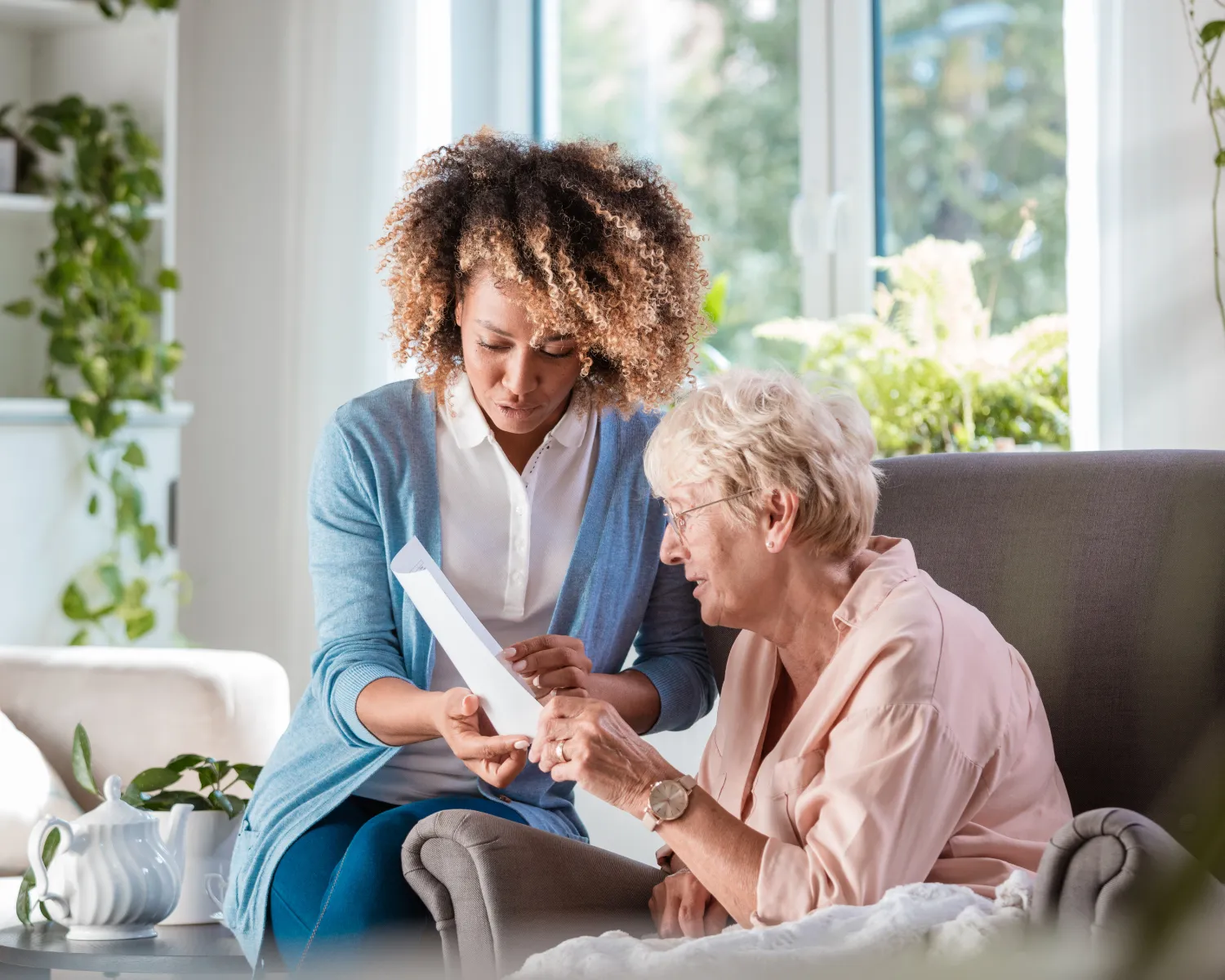 Young nurse assisting elderly patient at home